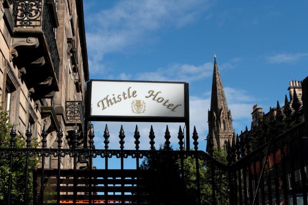 um sinal para uma casa de thrisel sobre uma cerca em Thistle Hotel em Edinburgo