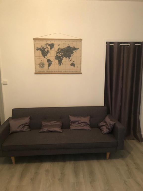 um sofá numa sala de estar com uma cortina em Appartement F3 agréable em Vichy