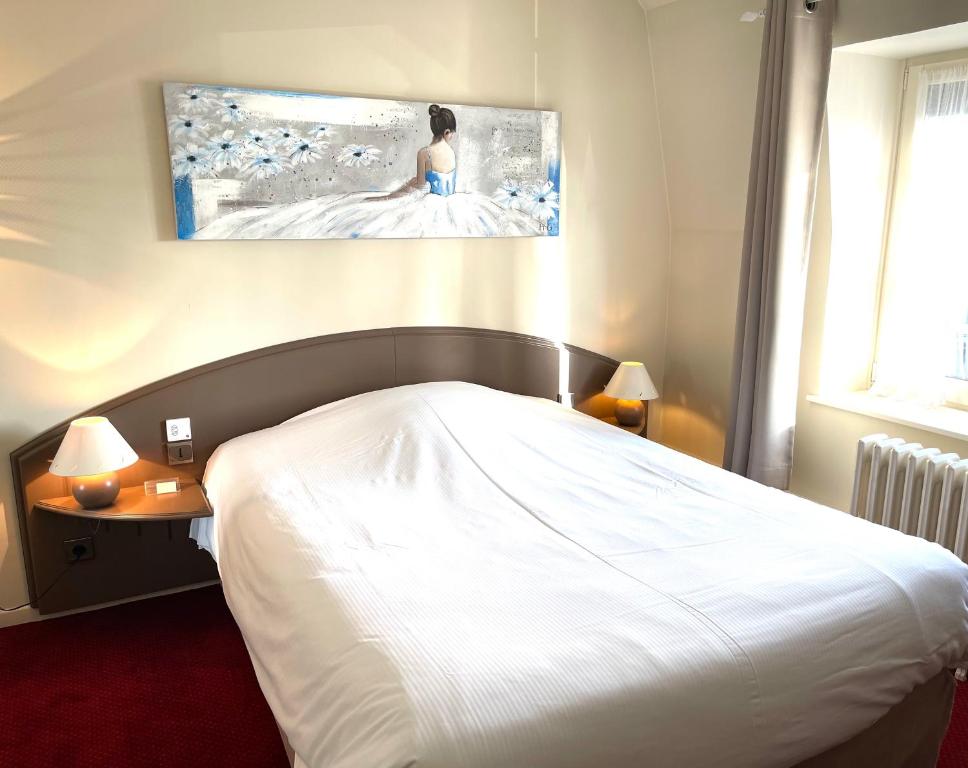 Un dormitorio con una cama blanca y una pintura en la pared en Hôtel - Restaurant "Histoire de Bistrot" en Isbergues