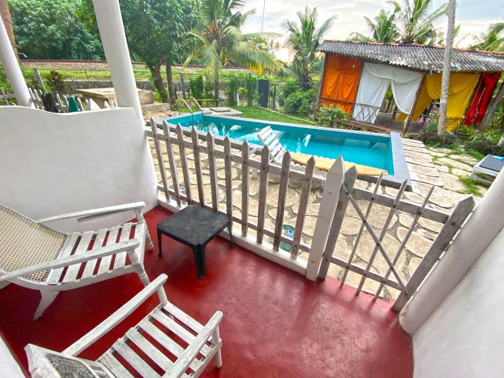 un balcón con 2 sillas y una piscina en Asanka Surf House & Resturant, en Midigama East