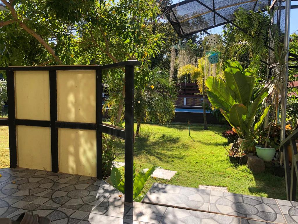 Elle offre une vue sur un jardin avec une porte et de la pelouse. dans l'établissement มุกดาสวรรค์ รีสอร์ท - Mukda Sawan Resort, à Mukdahan