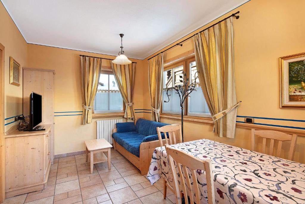 ein Wohnzimmer mit einem blauen Sofa und einem Tisch in der Unterkunft Chalet Betty Appartamento Muf in Livigno