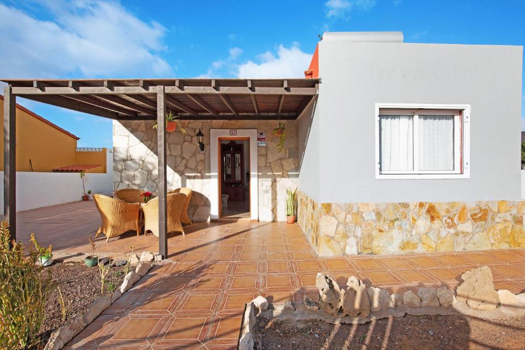 a patio of a house with a stone wall at Casa Chiripa in Tarajalejo