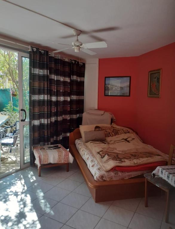 a bedroom with a bed and a red wall at Josip 1 Gajac in Novalja
