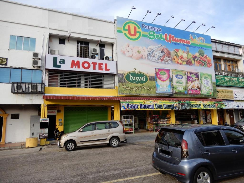 two cars parked in front of a building at LA MOTEL in Sungai Petani