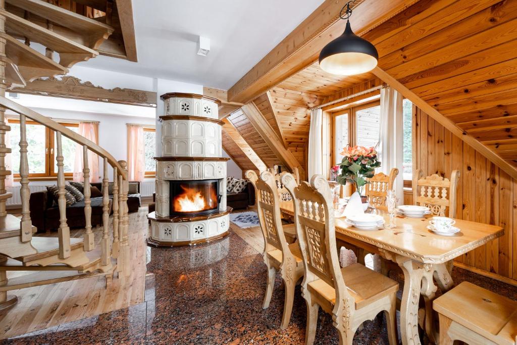 a dining room with a fireplace in a house at Domek Bachledówka Zakopane in Zakopane