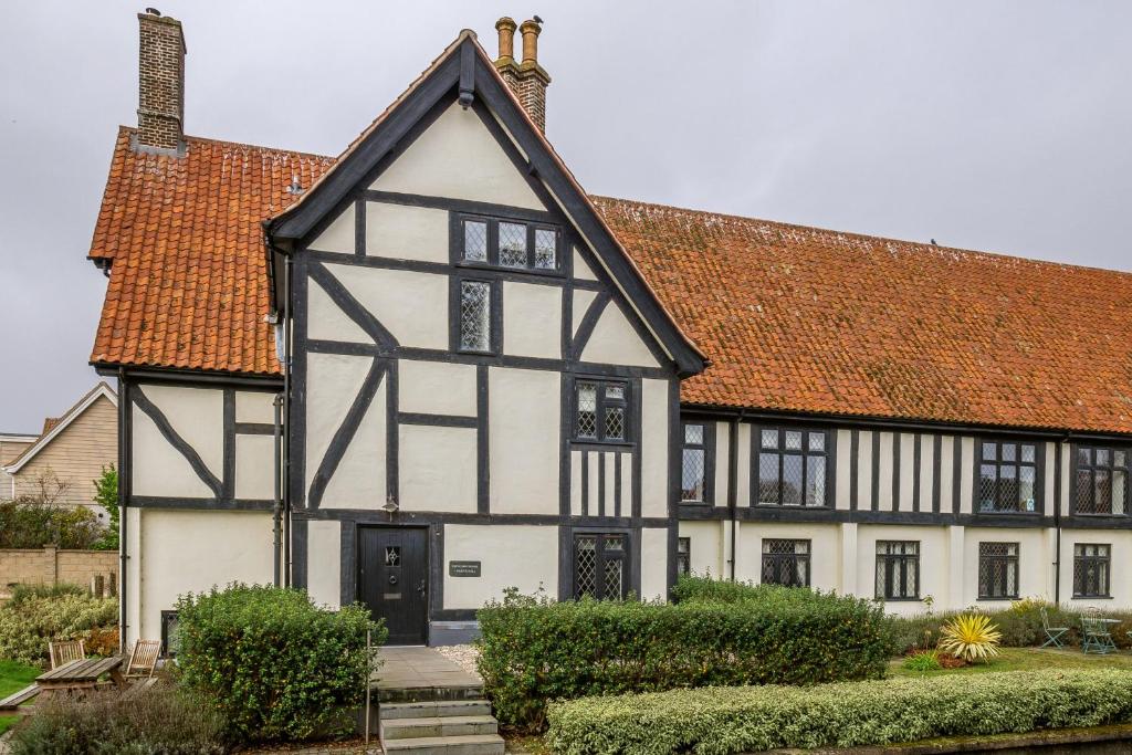 un antiguo edificio blanco y negro con techo rojo en Glencairn House, en Thorpeness