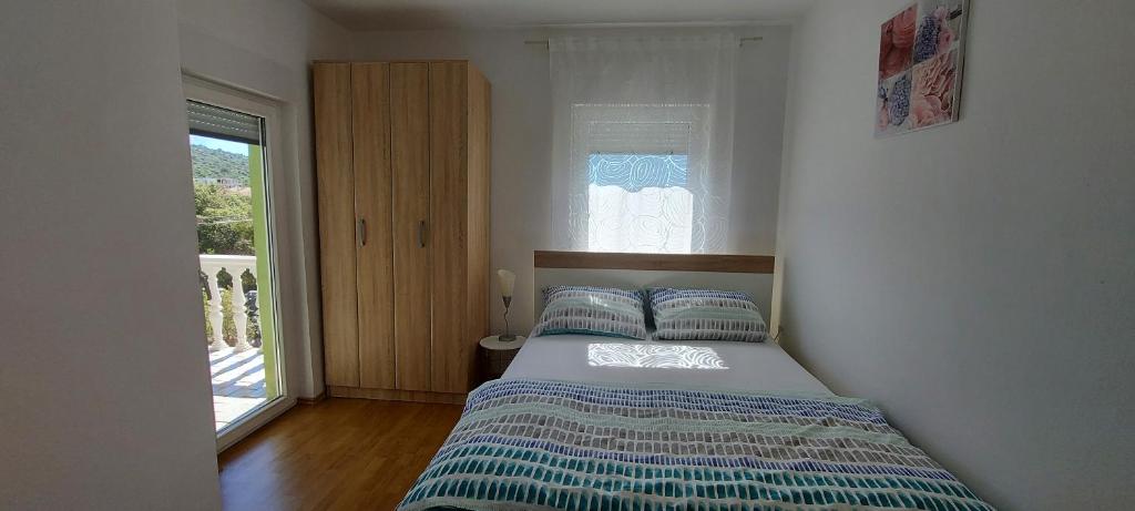 a bedroom with a bed and a window at Apartments Punta Kanica in Sevid