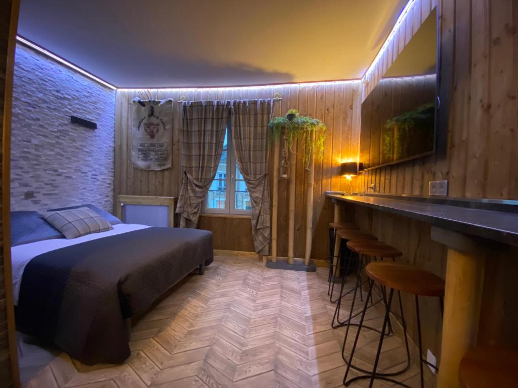 a bedroom with a bed and a bar in it at Hôtel Relais du Loir in La Flèche