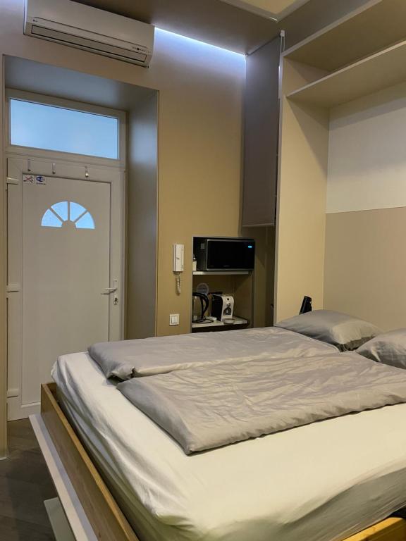 een slaapkamer met een groot bed en een raam bij Small Home Budapest Dráva in Boedapest