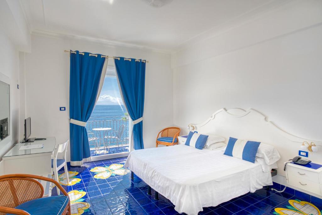 a bedroom with a bed and a large window at Hotel Cetus in Cetara