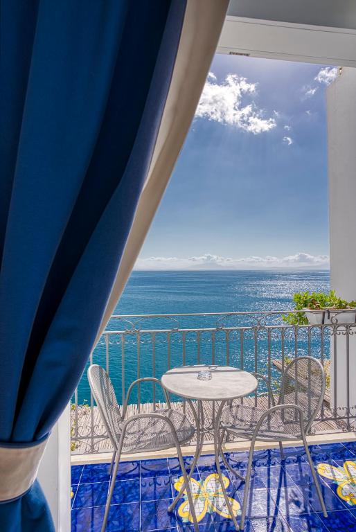 a balcony with a table and chairs and the ocean at Hotel Cetus in Cetara