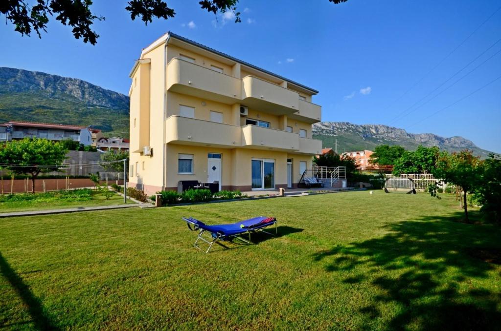 een blauwe bank in het gras voor een gebouw bij Apartment in Kastel Sucurac with sea view, balcony, air conditioning, WiFi 570-1 in Kaštela