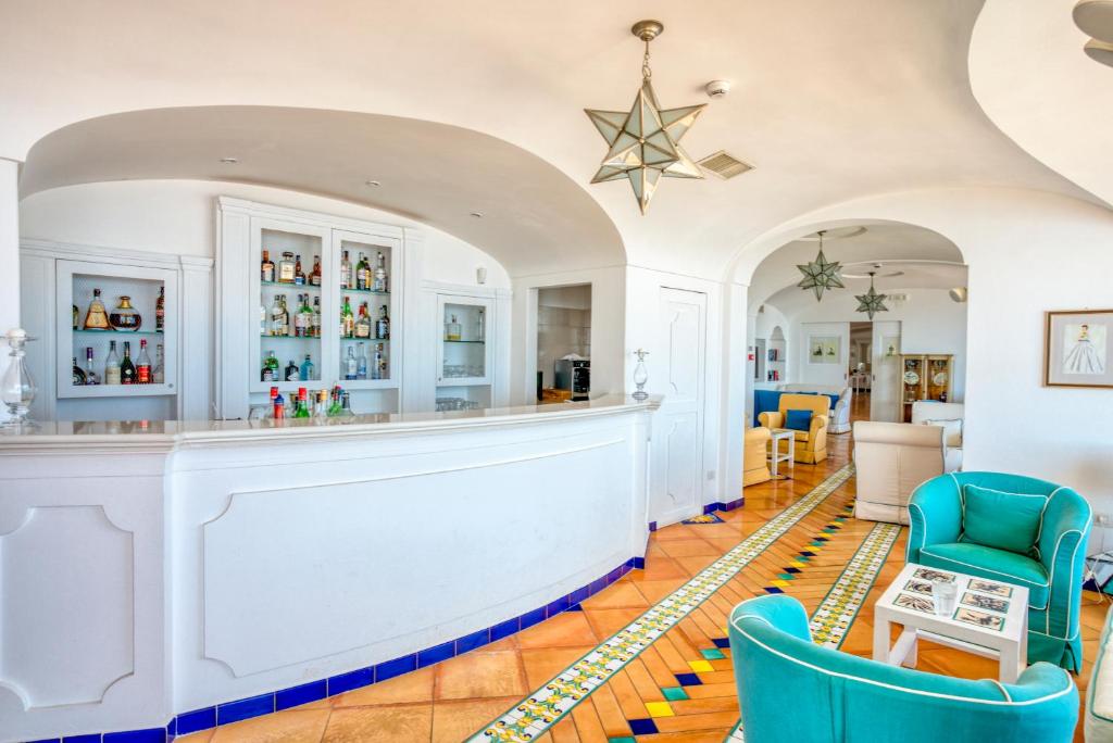 a bar in a living room with blue chairs at Hotel Cetus in Cetara