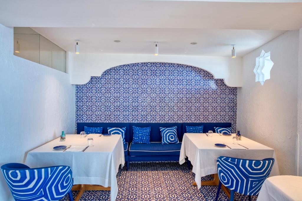 a restaurant with two tables and a blue wall at Hotel Cetus in Cetara
