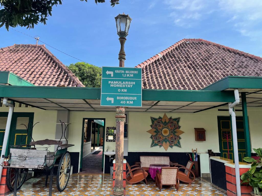 ein Straßenlicht mit einem Schild vor einem Gebäude in der Unterkunft Pamularsih Homestay in Yogyakarta