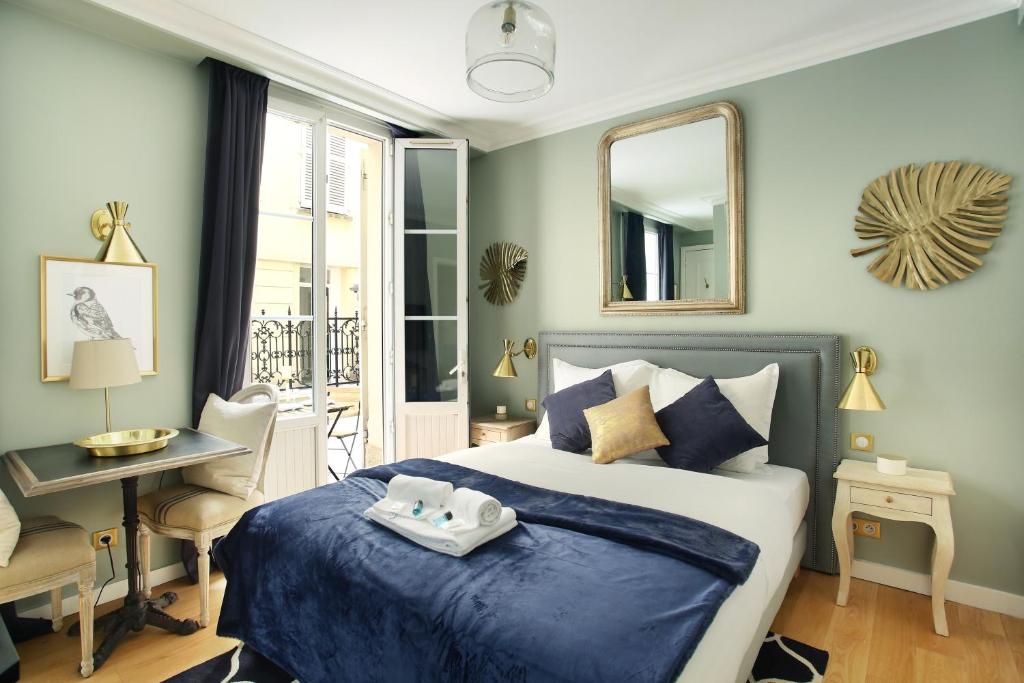 a bedroom with a bed and a desk and a mirror at Studio Opéra by Studio prestige in Paris