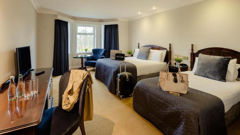 a hotel room with two beds and a television at Twin Trees Hotel & Leisure Club in Ballina