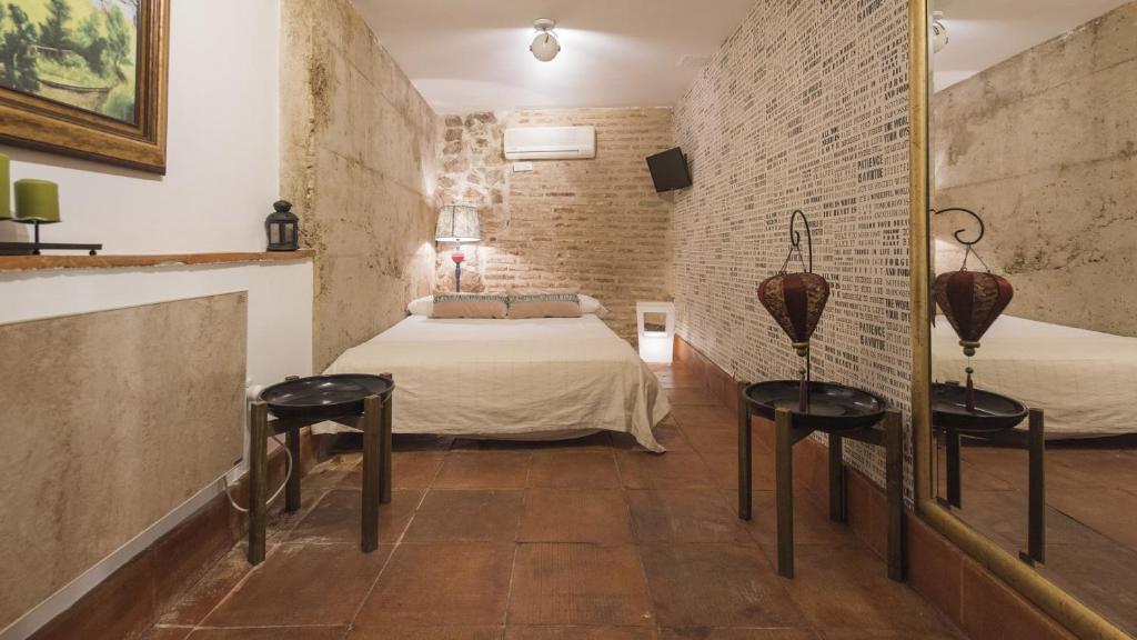 Zimmer mit einem Bett, 2 Tischen und einem Spiegel in der Unterkunft La Hospedería de los templarios de Toledo - Apartamentos Aloha Toledo in Toledo
