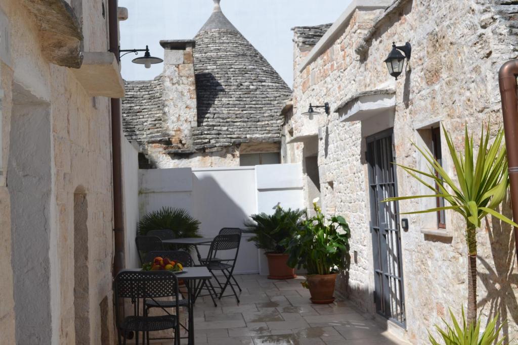 einen Innenhof in einem alten Haus mit einem Tisch und Stühlen in der Unterkunft Conversa De Amicis n°8 in Alberobello