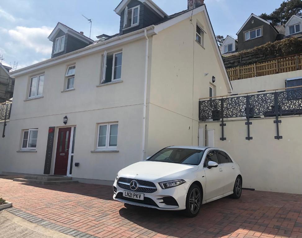 a white car parked in front of a white house at Artro House in Pembrokeshire