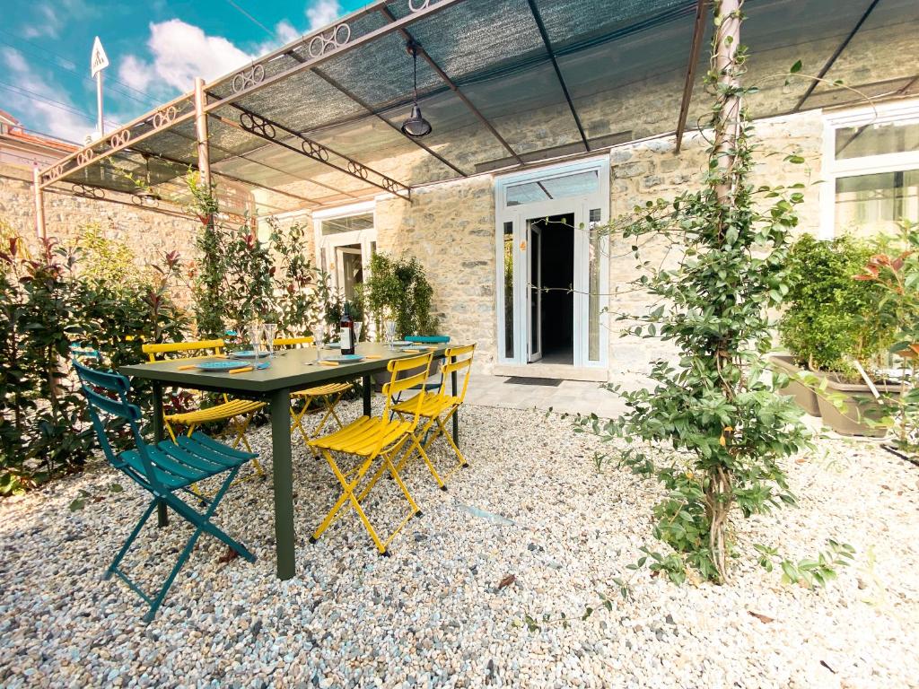 stół i krzesła siedzące na żwirowym patio w obiekcie New Agriloft 4 Palms clima, giardino e Wi-Fi a 50 mt dal mare w mieście Bordighera