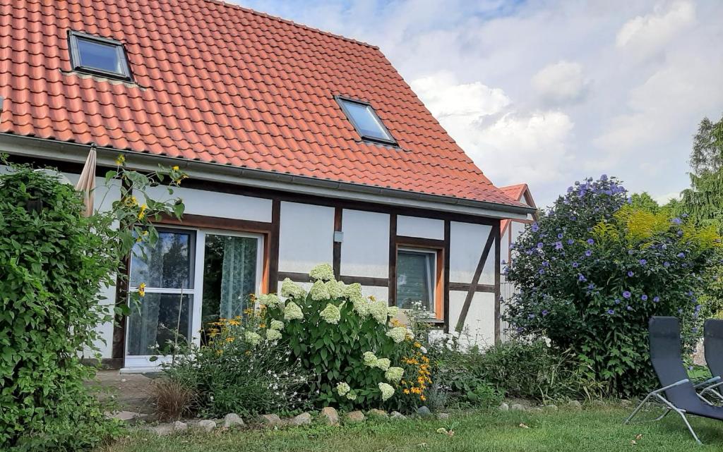 una casa con techo naranja y algunos arbustos en Honighof Hümmling en Prebberede