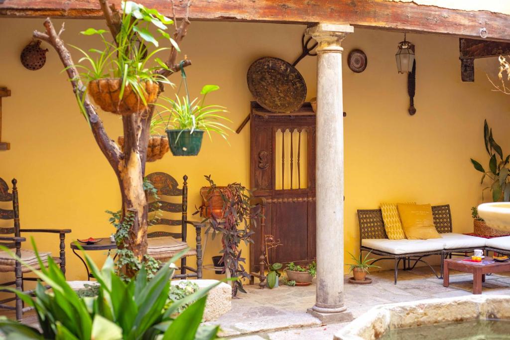 un patio con mesa, sillas y plantas en Alh Patio Apartamentos, en Granada