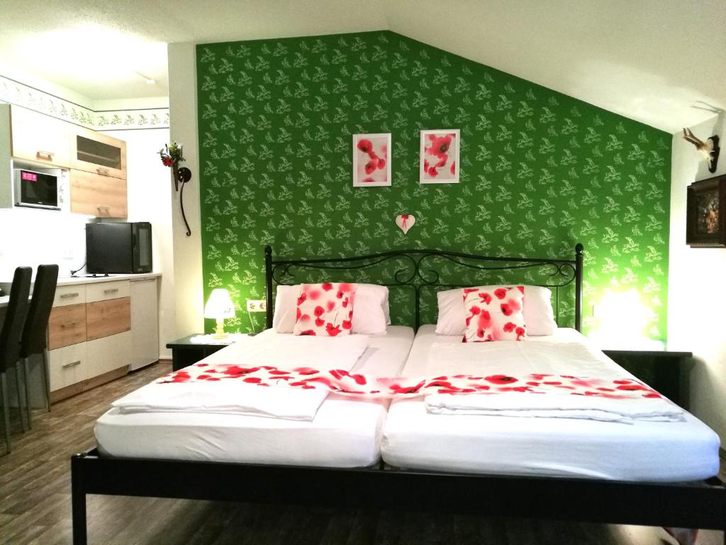 1 dormitorio con 1 cama grande y pared verde en Apartment Christopherhof 11, Grafenwiesen, en Grafenwiesen