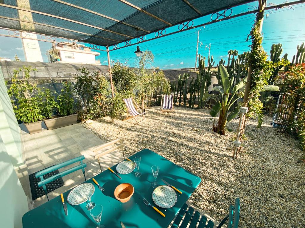 een patio met een blauwe tafel en stoelen in een tuin bij New Agriloft 2 Industrial- Giardino, clima , Wi-Fi a 50 mt dal mare in Bordighera