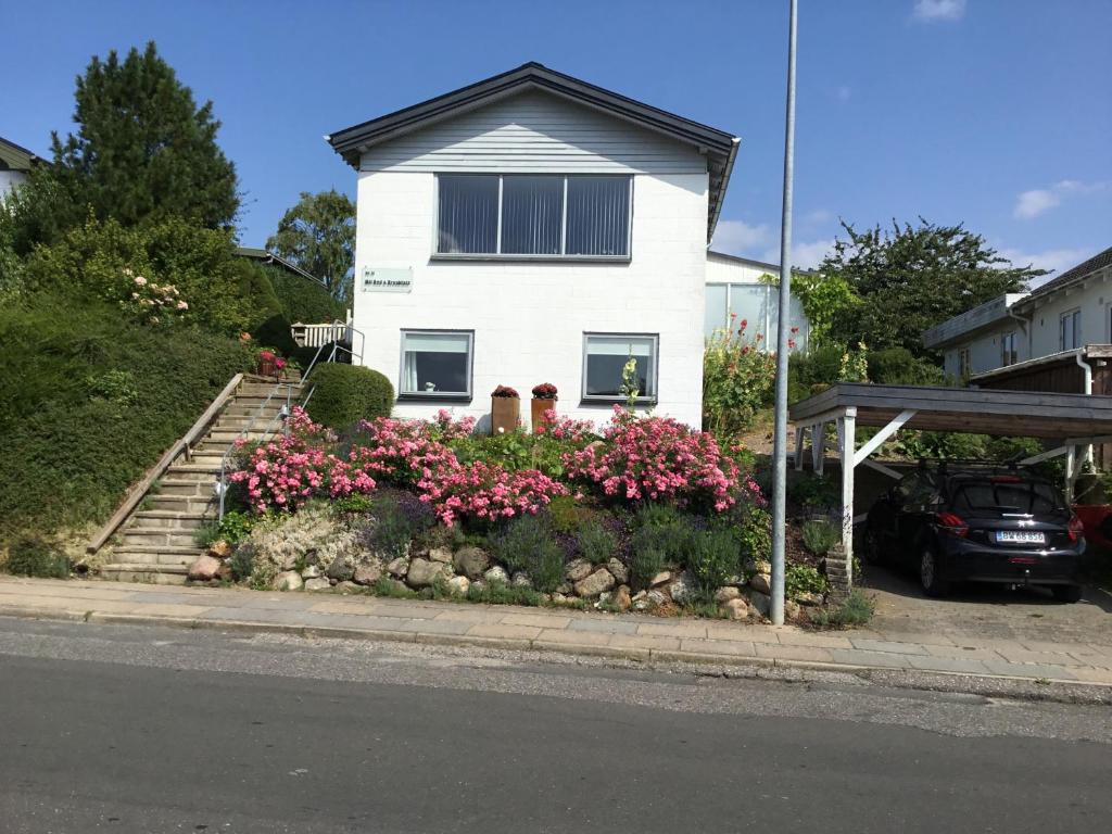 a white house with some flowers in front of it at Mit Bed & Breakfast in Kolding