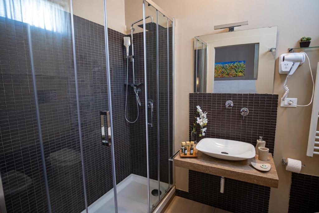 a bathroom with a glass shower and a sink at B&B Le Muse in Mondello
