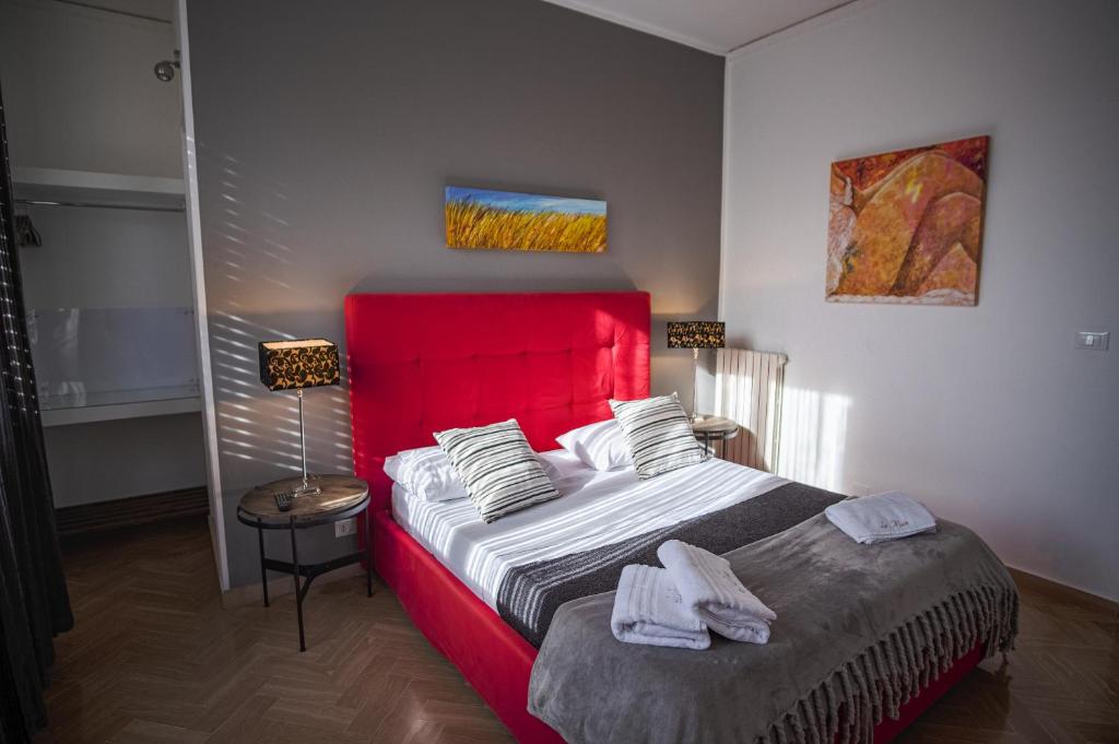 a bedroom with a large bed with a red headboard at B&B Le Muse in Mondello