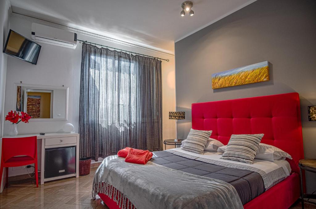 a bedroom with a large bed with a red headboard at B&B Le Muse in Mondello