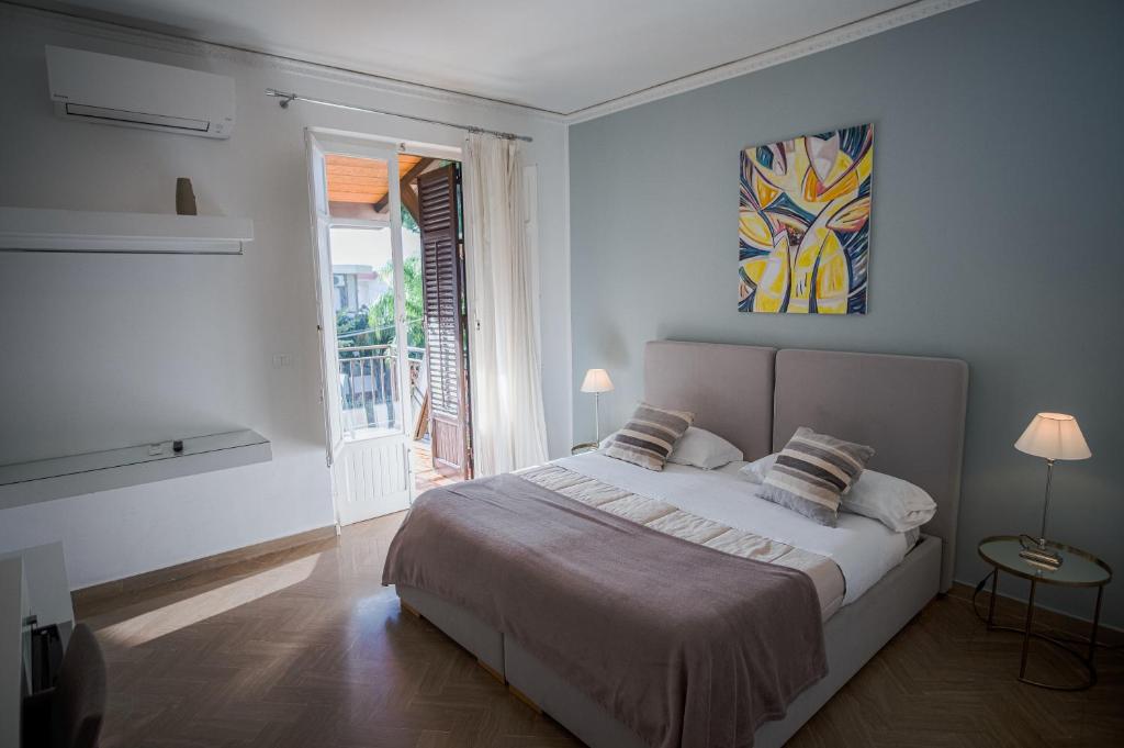 a white bedroom with a large bed and a window at B&B Le Muse in Mondello