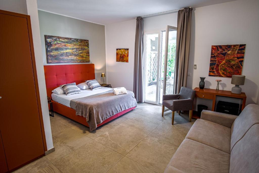 een slaapkamer met een bed, een stoel en een bank bij B&B Le Muse in Mondello