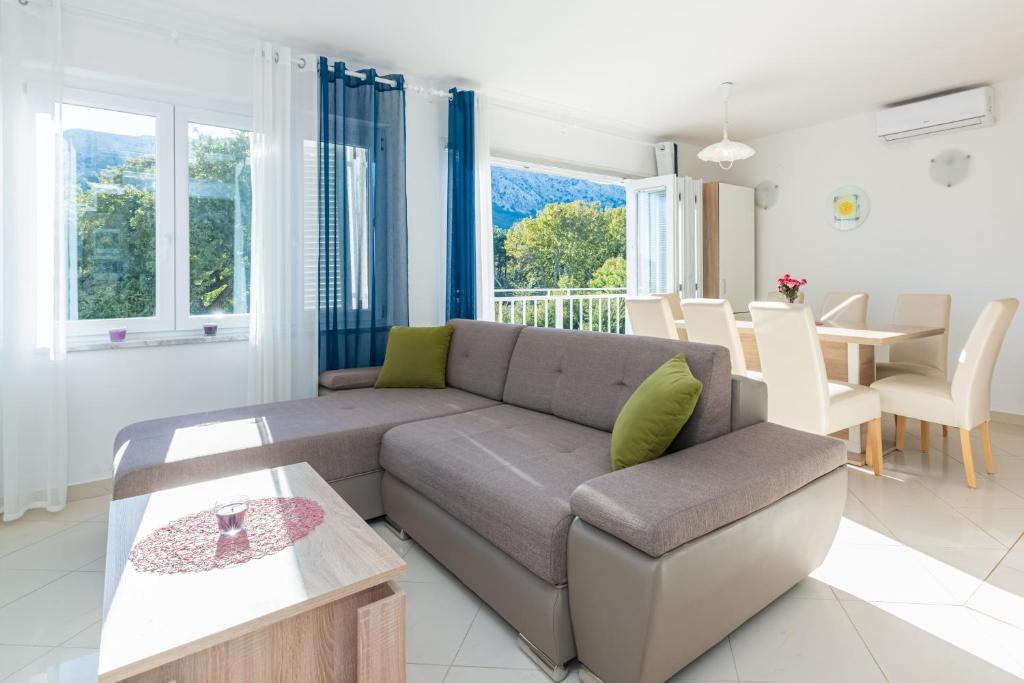 a living room with a couch and a table at Apartment Mimoza 6, Baska, Krk in Baška