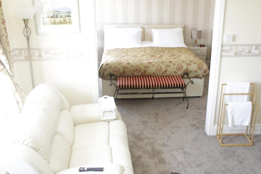 sala de estar con cama y sofá blanco en The Snowdonia Apartments, en Llandudno