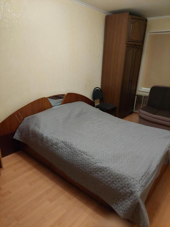 um quarto com uma cama com um edredão cinzento em 1 room aprtment 400 from sea em Liepāja