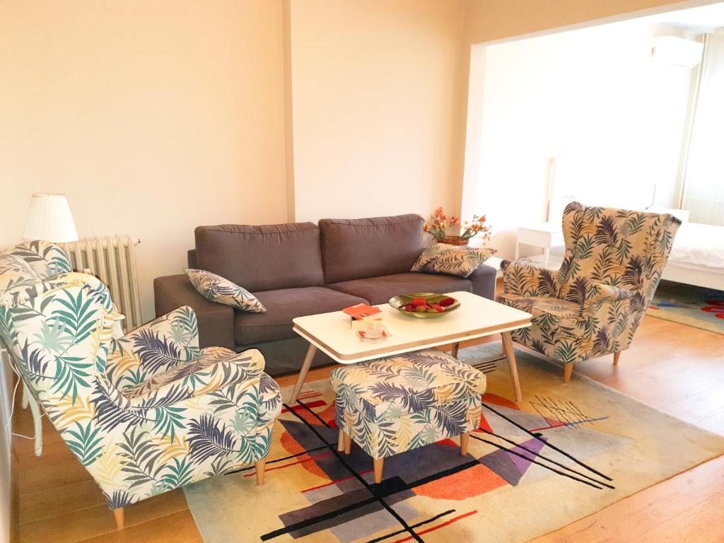 uma sala de estar com um sofá e duas cadeiras e uma mesa em Beautiful Jewel in Top Center em Sófia