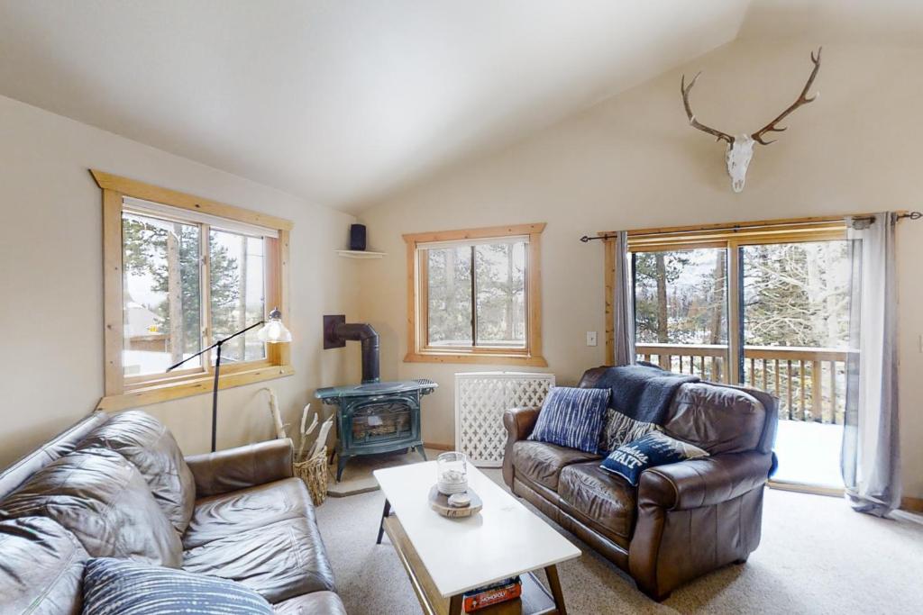 sala de estar con sofá de cuero y chimenea en Mountain Calling, en Grand Lake