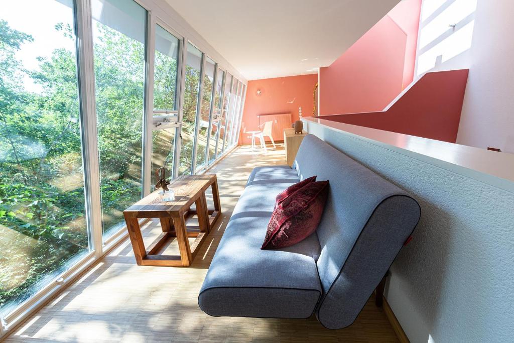 a living room with a blue couch and large windows at Darmstadt Loft in Darmstadt