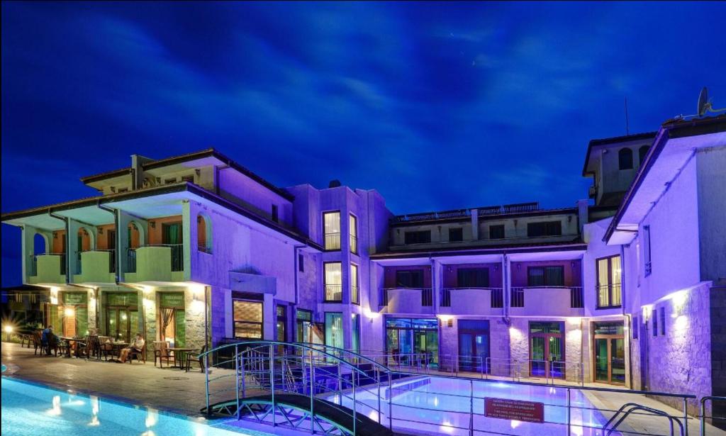 a building with a swimming pool at night at Hotel Lalov Egrek in Lozenets