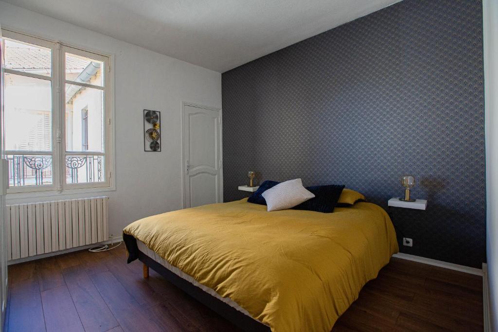 um quarto com uma cama com uma colcha amarela em Le Canal,Hyper centre, Cosy, fibre, parking privée, 1 a 4 pers em Montargis