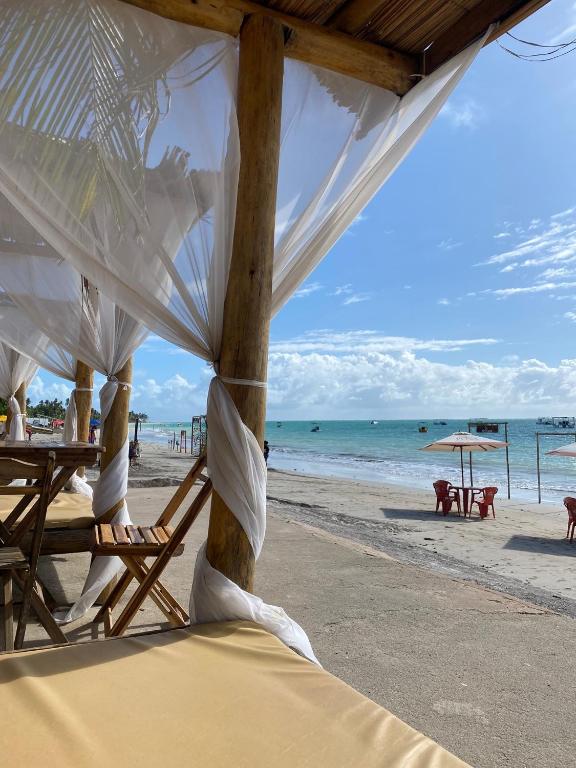 a beach with chairs and umbrellas and the ocean at Barra lounge in Maragogi