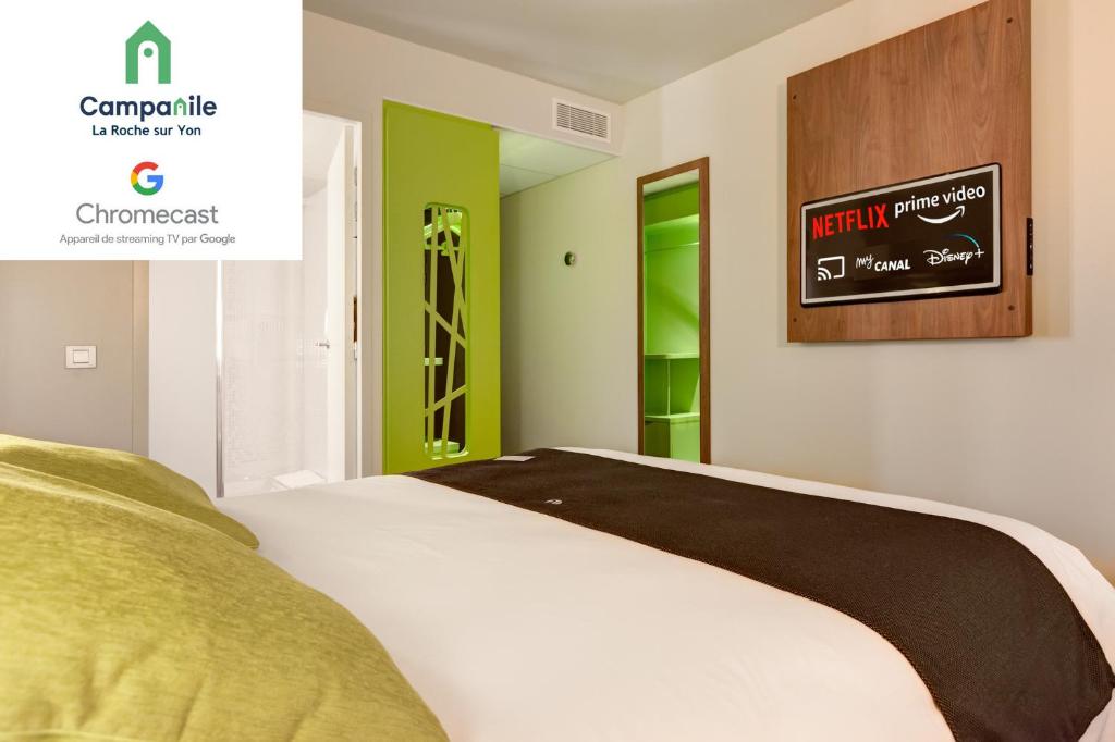 a bedroom with a white bed and a green door at Campanile La Roche Sur Yon Centre Gare in La Roche-sur-Yon