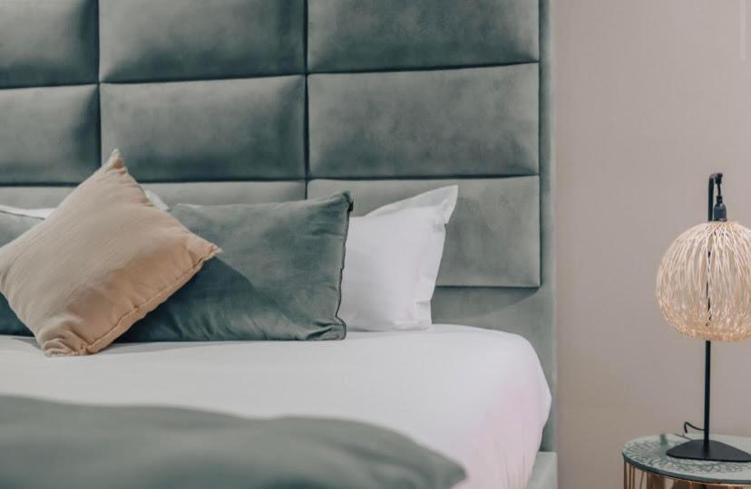 a bedroom with a white bed with pillows and a headboard at Palm Beach in Ajaccio