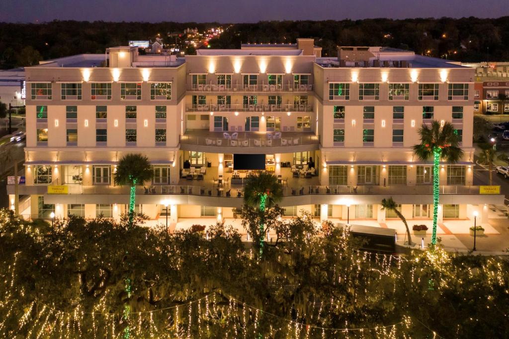 een groot wit gebouw 's nachts met verlichting bij Hilton Garden Inn Ocala Downtown, Fl in Ocala