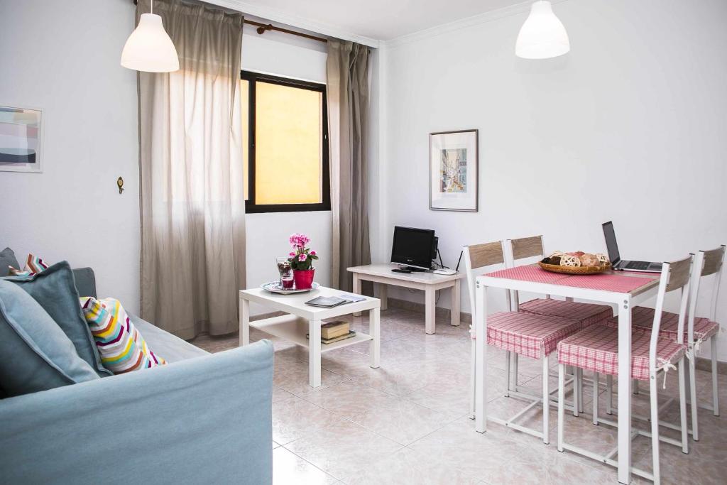 サン・クリストバル・デ・ラ・ラグーナにあるConfortable vivienda en La Laguna a 5 MIN tranvíaのリビングルーム(テーブル、椅子、ソファ付)