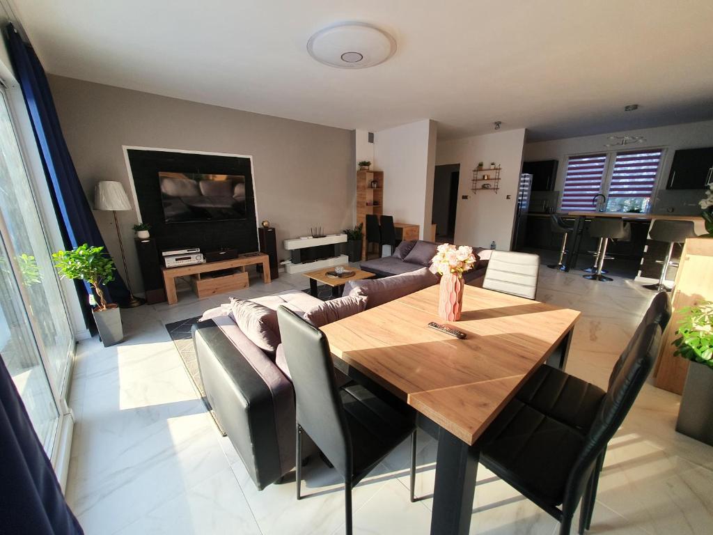 uma sala de estar com uma mesa e um sofá em Nowy Dom Apartament z Widokiem na Góry 8 osób em Bielsko-Biala